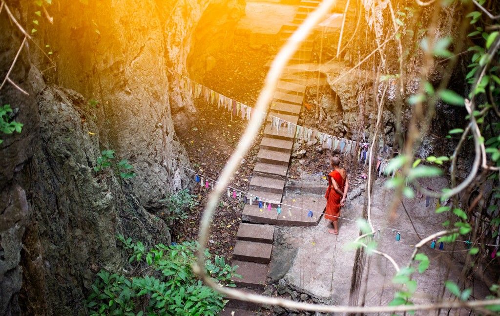 A monk observes one of the Killing Caves of Phnon Sampeau